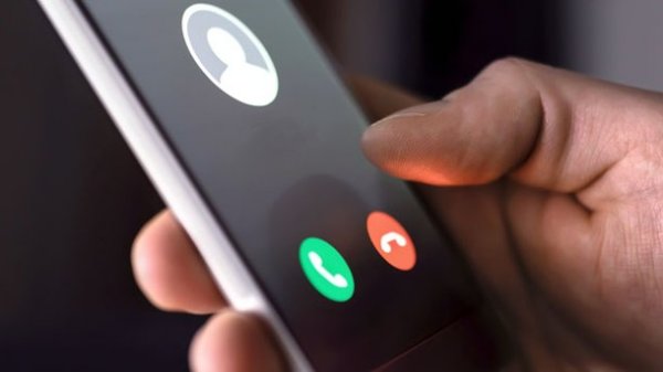 Hånd holder en mobiltelefon med et indgående opkald