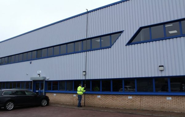 Inspektionsstang ved tagkanten på en industribygning.
