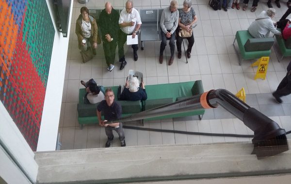 Rengøring af en højtliggende kant med børstemundstykke på lang sugestang.